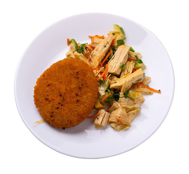 fishcake with soy asparagus and carrots, cucumbers and dilll. fish cutlet on a plate isolated. cutlet with vegetables top view