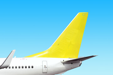 modern airplane tail side with white aircraft body light yellow fin and white winglet isolated on blue sky background. Parts of passenger jet plane. Aviation wallpaper Blank copy space design template