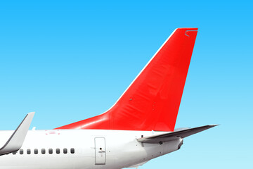modern airplane tail side with white aircraft body red fin and white winglet isolated on blue sky background. Parts of passenger jet plane. Aviation wallpaper Blank copy space design template