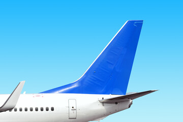 modern airplane tail side with white aircraft body blue fin and white winglet isolated on blue sky background. Parts of passenger jet plane. Aviation wallpaper Blank copy space design template