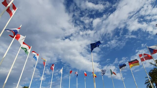 Flag of European Union and EU member flags on the background against a cloudy sky