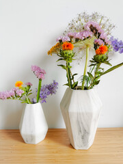 Small bouquet of wild spring flowers in faux marble vases