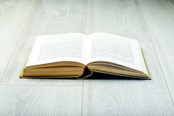 Book on the gray wooden floor. Reading, relaxation and interior concept.