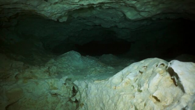 Divers in rocks of underwater cave Yucatan Mexico cenotes. Diving in clean and clear underground water.
