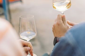 Friends drinking white wine on summer terrace outdoors. Event celebration concept. Summertime leisure. Close up