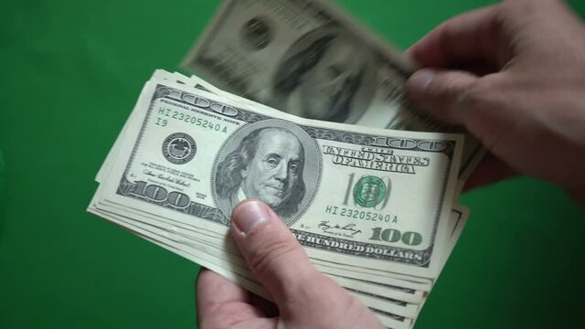 Man Counting 100 Dollars Isolated On Chroma Key Green Screen Background