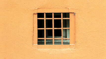 Fototapeta na wymiar orange wall with bars on the window