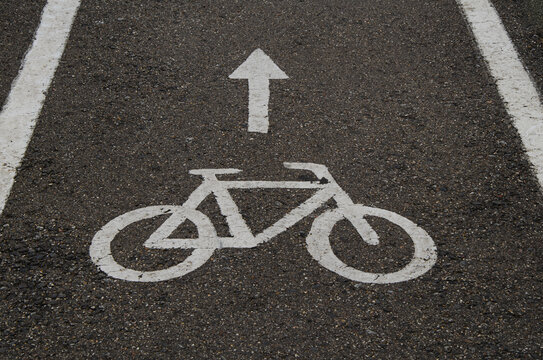 White "Bicycle Path" sign painted on the asphalt. Close-up of road markings for cyclists in the city. Traffic management.