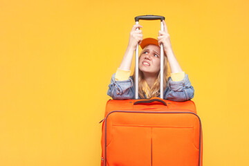 closed borders concept. unhappy girl tourist with luggage sad on a yellow isolated background, travel ban