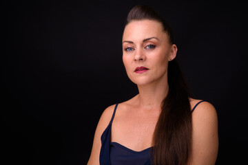 Fototapeta premium Portrait of mature beautiful woman against black background