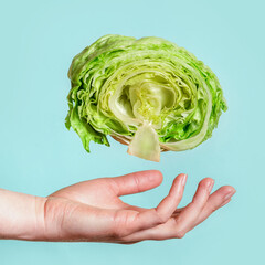 Obraz premium Balanced nutrition, diet or weight loss concept. Female hand and lettuce on a blue background. Vegan food.