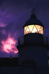 Faro con un cielo magenta brillante en Llanes, Asturias, España