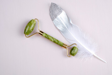 Jade face massager isolated on textured background. Gua Sha massager for face. Beauty skin care. 