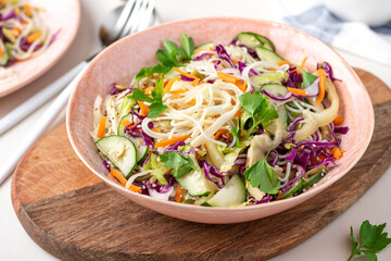Vegetarian food. Salad with noodles, vegetables and sesame seeds in a bowl close-up. Tasty and healthy food.