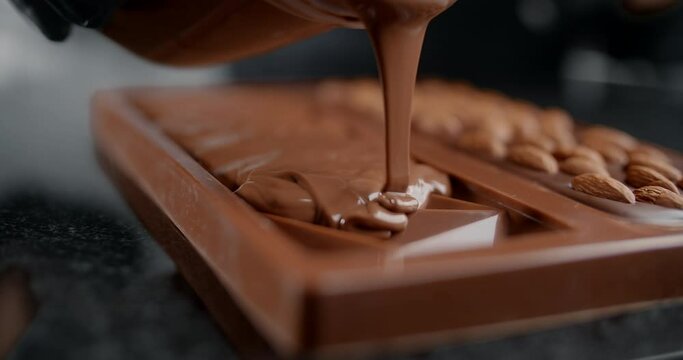 Chef confectioner makes chocolate bar - he pours hot melted chocolate to the silicone form, art of handmade chocolate, cooking desserts from chocolate and cocoa, making bars, 4k 120 fps Prores HQ