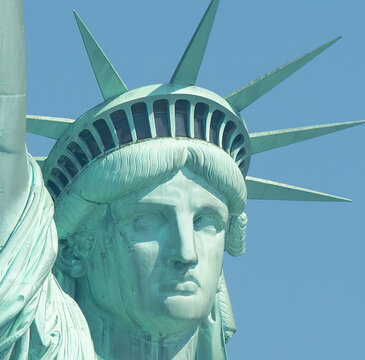 Close image of statue of liberty face and crown in a sunny day with pure blue sky