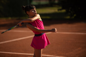 girl concentrated on tennis court and playing tennis