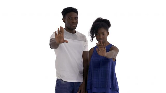 Portrait of dissatisfied African couple shaking heads and flashing palms forward to someone demanding to stop. isolated on white background. Stop gesture
