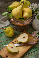 Ripe pears in a copper pot on a wooden old table, harvesting. Rustic style, still life