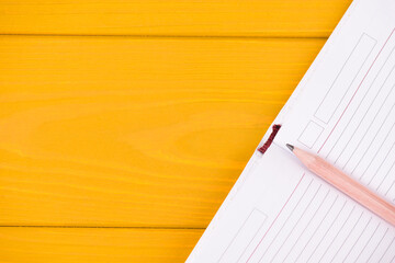 Planning concept. Top above overhead view close-up photo of an open planner and pencil isolated on yellow wooden background with copyspace