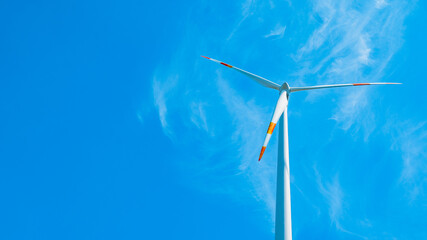 Wind power background - Blue cloudy sky with windmill