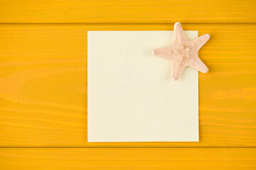 Fototapeta na wymiar Top above overhead view close-up photo of blank note and starfish isolated on yellow wooden background with copyspace