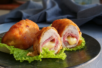 Schnitzel cordon bleu, chicken cutlet wrapped around ham and cheese, breaded and fried.