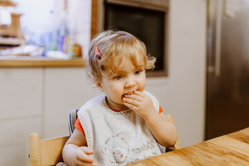 Fototapeta premium Baby girl eating cookie