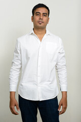 Portrait of handsome Indian businessman against white background