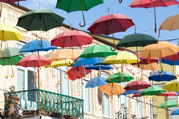 Fototapeta na wymiar colorful umbrellas on the street with balcony