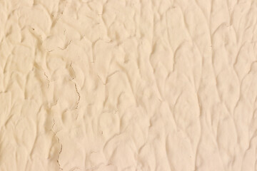 Painted wall with cracks and light peach paint texture. Abstract background