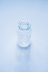 glass ampoule of medicine on a blue background