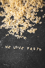 I love pasta sign formed of Italian letter shaped pasta product on the black concrete background