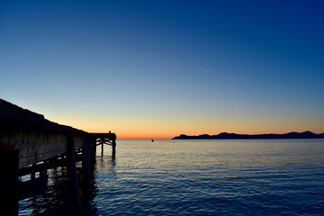 Fototapeta premium Sunrise over palma de port de pollensa beach in Mallorca, Spain with jetty / pier 