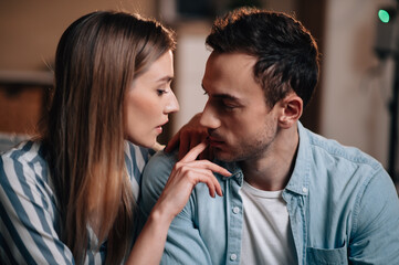 Portrait of a young couple in casual clothes on the couch in hugging each other