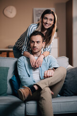 Fototapeta premium Portrait of a young couple in casual clothes on the couch in hugging each other