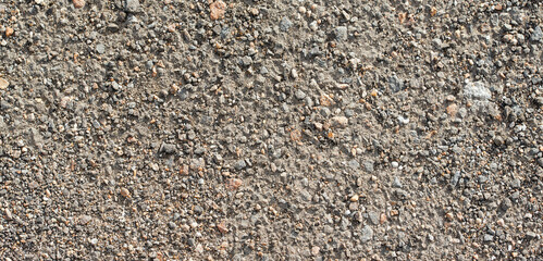 An old, stone-shattered road on a sunny day, from above. 