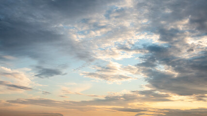 Obraz premium sun sets behind the clouds in the blue evening sky as a natural background