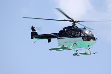 Bo-105 helicopter making a low pass over the sea