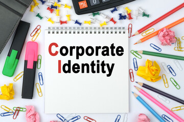 On the table is a calculator, diary, markers, pencils and a notebook with the inscription - Corporate Identity