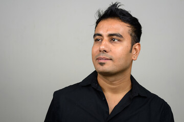 Portrait of handsome Indian businessman against white background