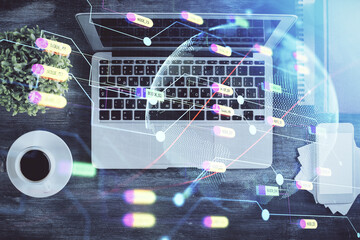 Double exposure of map hologram drawing over study table background with computer. Concept of international network. Top view.