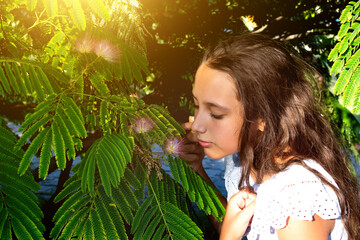 Portrait of a beautiful tanned caucasian cute girl in the tropical greenery. Travel, vacation, warm countries.