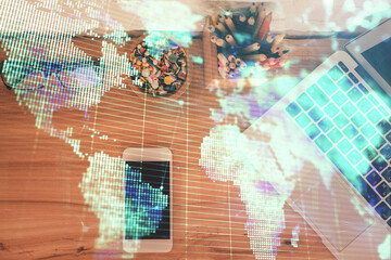 Double exposure of business theme hologram over desktop with phone. Top view. Mobile international trade connection concept.