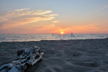 Silouhette of paddleboarder at sunset on Lake Michigan, Muskegon State Park beach