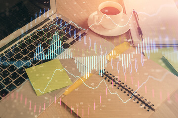 Multi exposure of forex graph drawing and desktop with coffee and items on table background. Concept of financial market trading