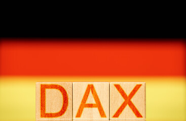 dax index concept. wooden blocks with the word dax on the background of the national flag of germany