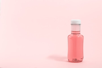 Bottle of pink water drink, background with copy space