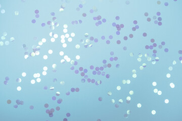 Delicate blue color pastel festive background with holographic round confetti. Flat lay style with copy space for text, design. Trendy Holiday concept. Perfect backdrop for social media blog, postcard