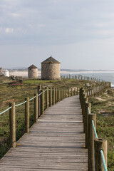 Fototapeta premium Windmills and coastal path at beach Praia da Apúlia, Esposende, Portugal